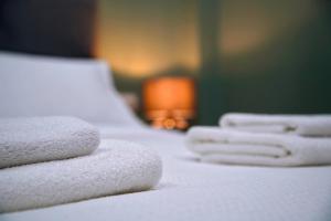 a group of white towels sitting on a bed at Aegean Modern Escape VIPGreece in Piraeus