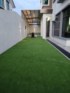 a lawn in the middle of a building with green grass at Cik Yam Homestay Pool, Melaka l For Malay Only in Melaka +23 photos