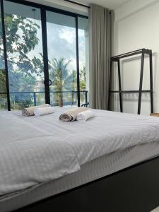 a bed with two towels on it with a window at Mates Villa in Weligama