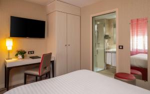 a hotel room with a bed and a desk and a bedroom at Best Western Plus Richelieu in Limoges +138 photos