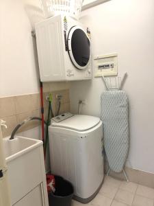 a small bathroom with a washing machine and a sink at 14 Roomy Restrelax Eastperth 2brparking in Perth