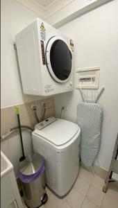 a bathroom with a microwave on top of a toilet at 14 Roomy Restrelax Eastperth 2brparking in Perth +13 photos