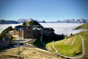 a building on top of a hill with fog in the valley at Appartement cosy in La Mure