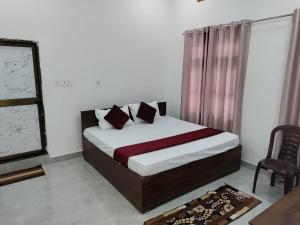 a bedroom with a bed and a chair and a window at The Ashoka Palace Near Ram Mandir in Ayodhya