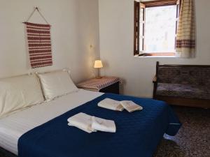 a bedroom with a bed with towels on it at Beliotis' House in Apérathos