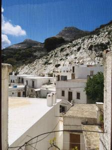 a group of white buildings in front of a mountain at Beliotis' House in Apérathos