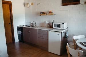 a small kitchen with a sink and a microwave at Langmeil Cottages in Tanunda