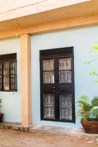 カンパラにあるesteez houseの黒い扉と窓が2つある家