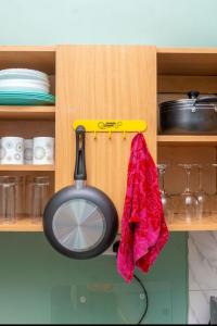 カンパラにあるesteez houseのキャビネットから鍋がぶら下がっているキッチン