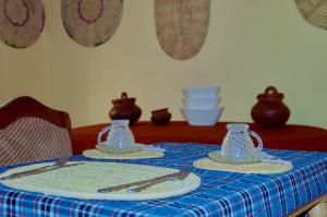 un tavolo con una tovaglia blu con piatti e utensili di Biez Homestay a Karatu