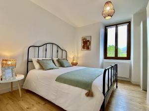 a bedroom with a large bed and a window at Escapade Boheme in La Mure