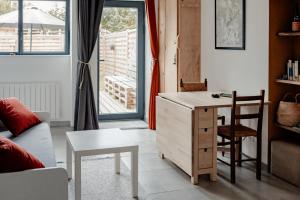 a living room with a desk and a chair at Gîte Terre - 1-4 pers, à 20 mins de Vulcania et du Puy-de-Dôme, 35 mins du Sancy in Gelles