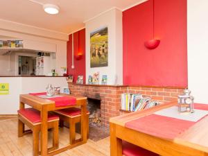 a kitchen with red walls and a table and chairs at YHA Truleigh Hill in Shoreham-by-Sea +46 photos