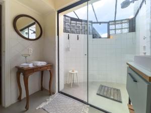 ein Badezimmer mit Dusche, Waschbecken und Spiegel in der Unterkunft Charme na Granja - Condomínio in Carapicuíba + 45 Fotos