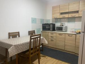 a small kitchen with a table and a microwave at Petar Apartment in Mavrovo