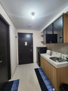 a kitchen with a sink and a black door at Spacious Comfortable Apartement South Surabaya in Surabaya +19 photos