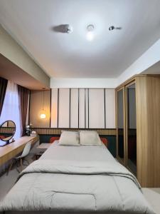 a bedroom with a large bed and a desk at Spacious Comfortable Apartement South Surabaya in Surabaya