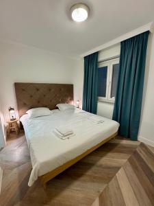 ein Schlafzimmer mit einem großen Bett mit grünen Vorhängen in der Unterkunft Cozy Panorama Flat by the Beach in Knokke-Heist