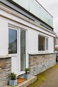 una casa blanca con ventana y dos macetas en Life of Riley, en St Ives