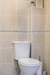 Un baño con inodoro y una pared de azulejos. en Life of Riley, en St Ives 13 fotos más