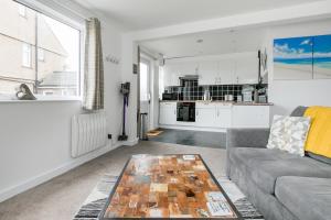 una sala de estar con un sofá y una mesa en Life of Riley, en St Ives