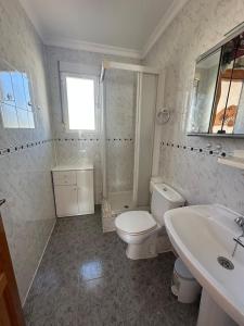 a white bathroom with a toilet and a sink at Chalet con piscina privada in El Verger +14 photos