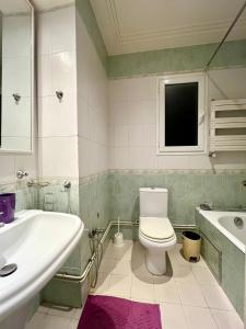 a bathroom with a toilet and a sink and a tub at Belle Appartement pour Familles S2 El Nasser 1 Ariana in Ariana