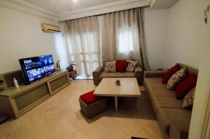 a living room with a couch and a tv at Belle Appartement pour Familles S2 El Nasser 1 Ariana in Ariana