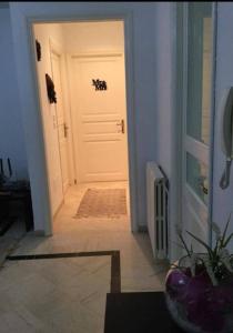 a hallway with a white door with a plant next to it at Belle Appartement pour Familles S2 El Nasser 1 Ariana in Ariana