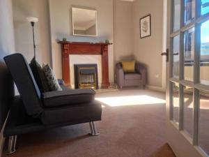 a living room with a chair and a fireplace at Campbeltown Harbour View in Campbeltown