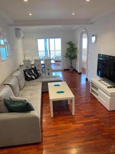 a living room with a couch and a coffee table at Appartement 3 chambres, piscine et vue mer in Santa Pola