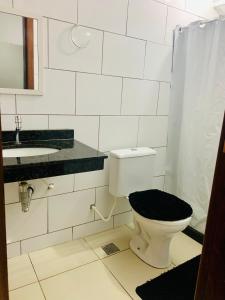 ein weißes Badezimmer mit Toilette und Waschbecken in der Unterkunft Ap praia dos anjos com vista in Arraial do Cabo + 26 Fotos