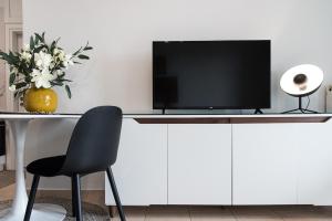 Elle comprend un bureau avec une télévision, une chaise et des fleurs. dans l'établissement Salto - Free Parking #Skgbnb, à Thessalonique