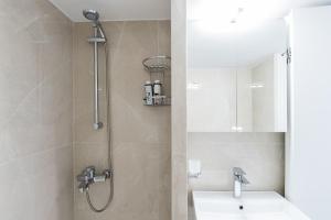 une salle de bain avec une douche avec un lavabo et un miroir dans l'établissement Salto - Free Parking #Skgbnb, à Thessalonique 12 autres photos