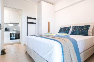 une chambre blanche avec un grand lit avec des oreillers bleus dans l'établissement Salto - Free Parking #Skgbnb, à Thessalonique
