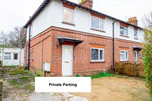 une maison en briques avec une porte blanche dans une cour dans l'établissement Cosy Oxford Getaway with Free Parking, Minutes from City Centre, à Oxford