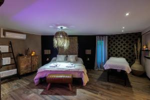 a bedroom with a large bed and a purple ceiling at pampa-chambre-hote et spa in Warhem