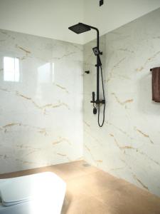 a bathroom with a shower with white marble walls at Mates Villa in Weligama +30 photos