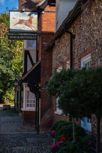 un cartello sul lato di un edificio in mattoni di The Stag and Huntsman at Hambleden a Henley on Thames