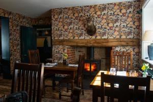 una sala da pranzo con tavolo e camino di The Stag and Huntsman at Hambleden a Henley on Thames