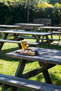 un tavolo da picnic con un piatto di cibo e un drink sopra di The Stag and Huntsman at Hambleden a Henley on Thames