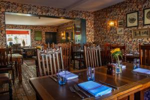 un ristorante con tavolo e sedie in legno e specchio di The Stag and Huntsman at Hambleden a Henley on Thames