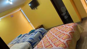 a bedroom with a bed and a tv on a wall at Hotel Residencial Miraflores in Loja