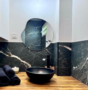 a bathroom with a black sink and a mirror at Studio-St Pierre centre proche toutes commodités in Saint-Pierre