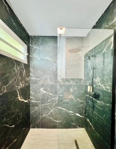 a bathroom with a shower with black marble at Studio-St Pierre centre proche toutes commodités in Saint-Pierre +12 photos