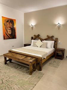 a bedroom with a wooden bed and a painting of a tiger at M&M Villas Zanzibar in Kidoti