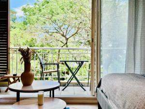 a room with a bed and a table and a balcony at Studio-St Pierre centre proche toutes commodités in Saint-Pierre