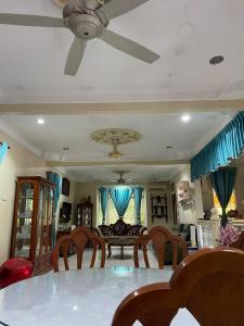 a dining room with a ceiling fan and a table at Serambi Kenangan in Kampong Padang