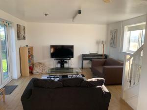 1 Bedroom annex, private bathroom, peaceful area في Claypits: غرفة معيشة مع أريكة وتلفزيون بشاشة مسطحة