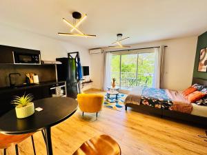 a bedroom with a bed and a table and a dining room at Studio-St Pierre centre proche toutes commodités in Saint-Pierre